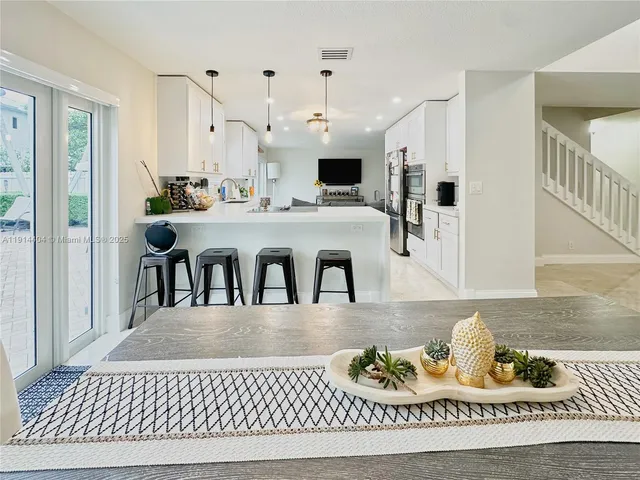a living room with kitchen island furniture and a chandelier