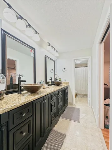 a spacious bathroom with a granite countertop sink and a mirror