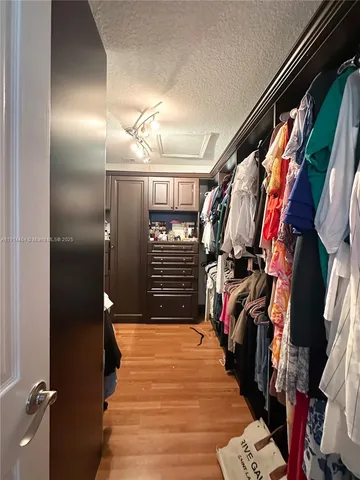 a view of walk in closet with clothes and shoes