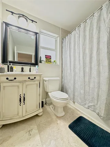a bathroom with a toilet a sink and a mirror