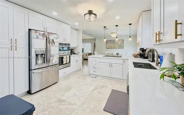 a kitchen with stainless steel appliances a refrigerator sink and cabinets