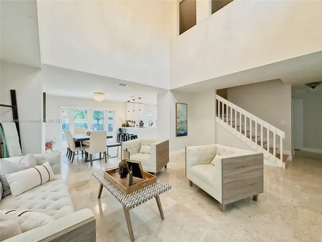 a living room with furniture and a dining table
