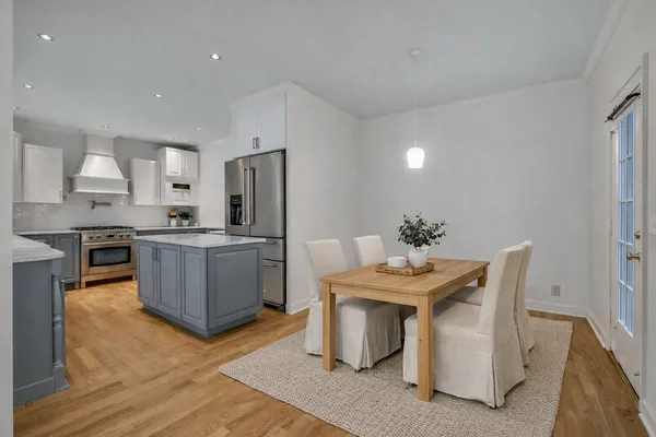 a kitchen with granite countertop a table chairs stove a sink and dishwasher