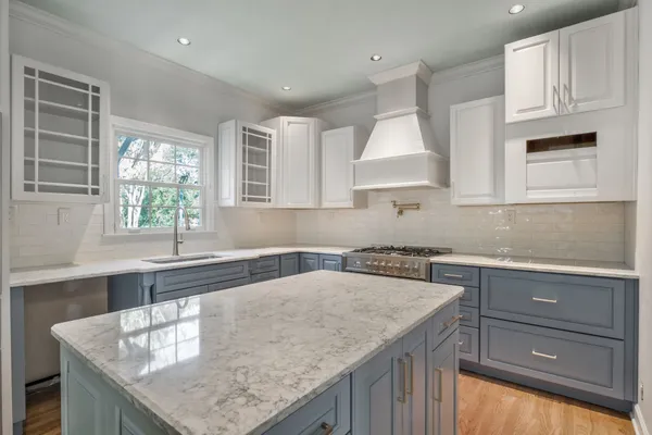 a kitchen with granite countertop a sink a stove and cabinets