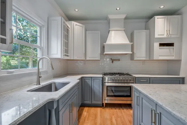 a kitchen that has a sink a stove and cabinets