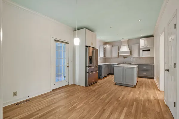 a kitchen with a refrigerator and wooden cabinets