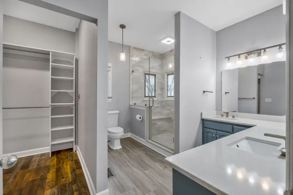 a bathroom with a double vanity sink toilet and shower