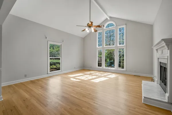 a view of an empty room with a window and wooden floor