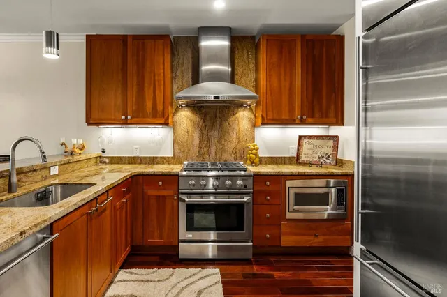 a kitchen with stainless steel appliances granite countertop a stove and a sink