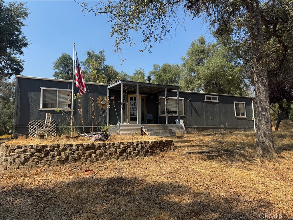 a front view of a house with a tree