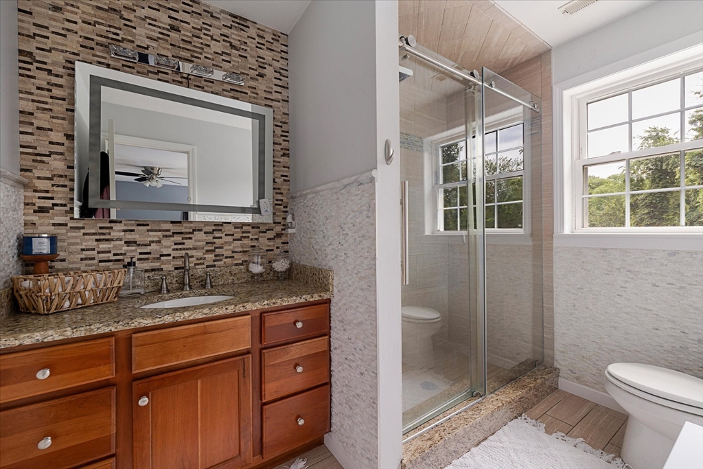 7 Beaman Lane Marlborough, MA 01752 - Photo 27 of 42 a bathroom with a granite countertop sink a mirror a vanity and a shower