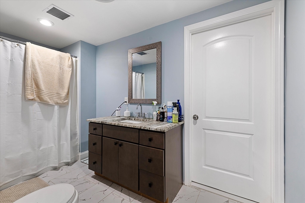 7 Beaman Lane Marlborough, MA 01752 - Photo 31 of 42 a bathroom with a granite countertop sink a toilet and a mirror