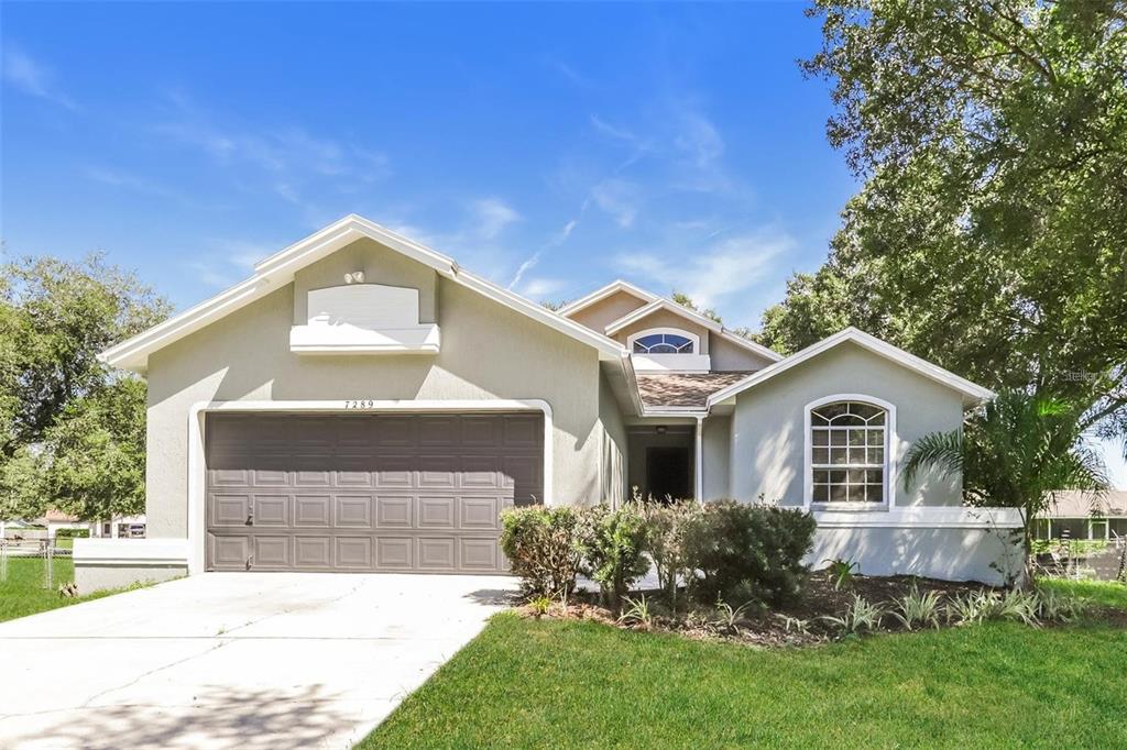 7289 Pebble Pass Loop Lakeland, FL 33810 - Photo 1 of 1 a front view of a house with a yard and garage