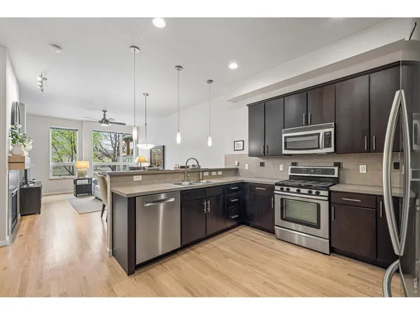 a large kitchen with stainless steel appliances and wooden cabinets