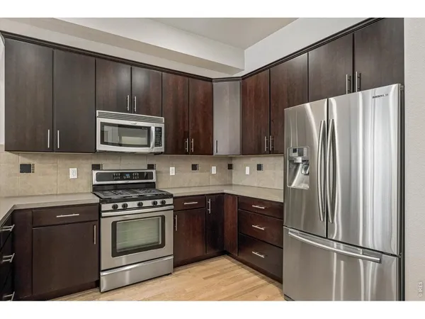 a kitchen with granite countertop wooden cabinets and stainless steel appliances