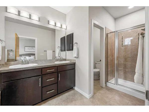 a bathroom with a sink double vanity granite tub and a mirror