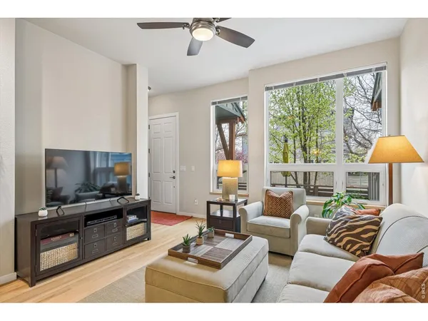 a living room with furniture a large window and a flat screen tv