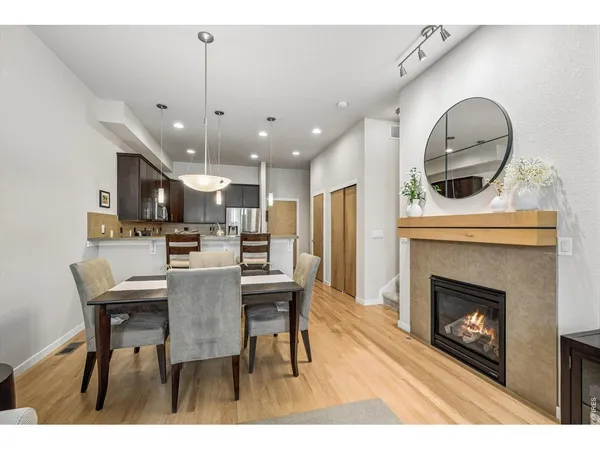 a view of a dining room with furniture a fireplace and wooden floor
