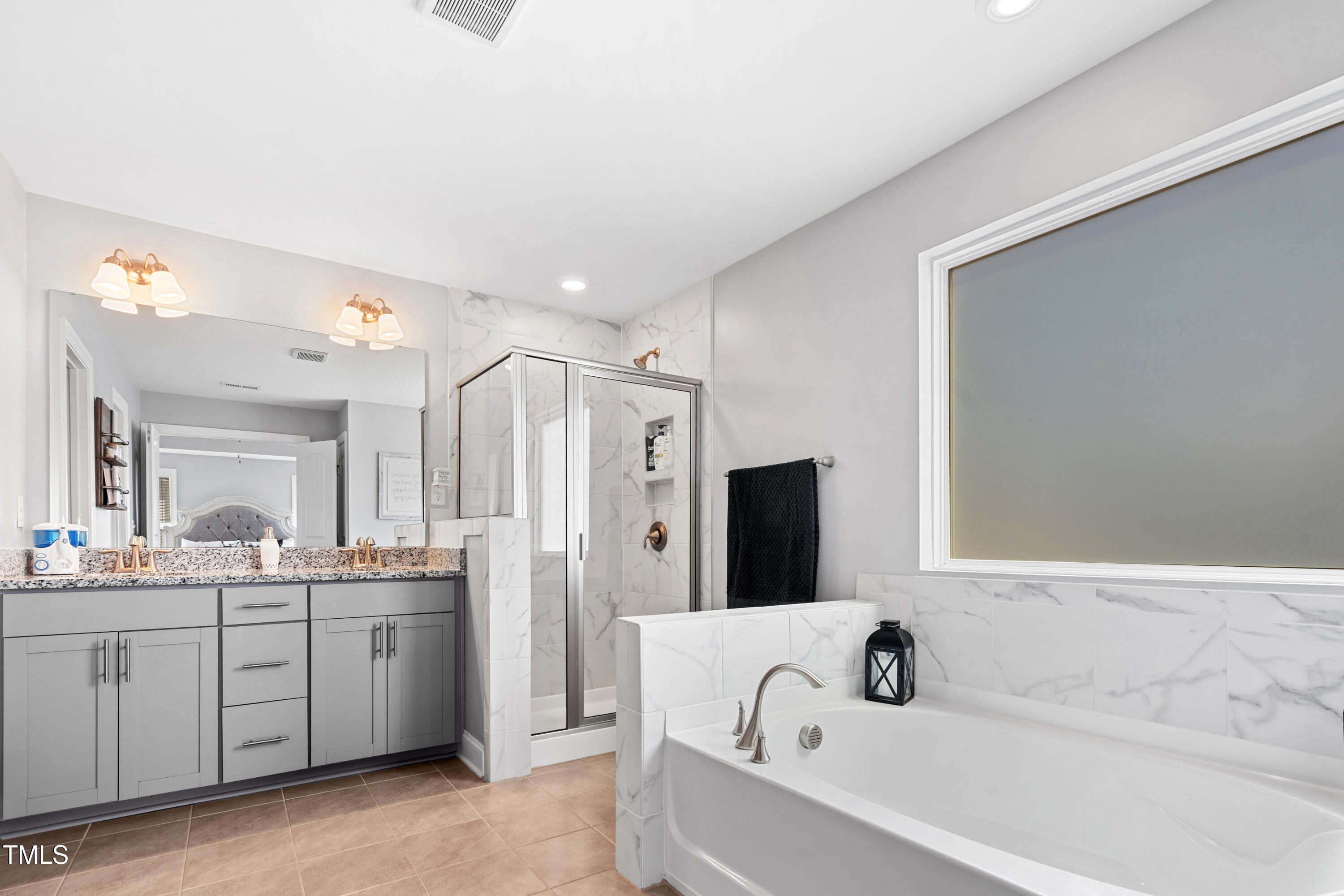 115 Cliffview Drive Garner, NC 27529 - Photo 25 of 52 a bathroom with a bathtub a double vanity sink and mirror