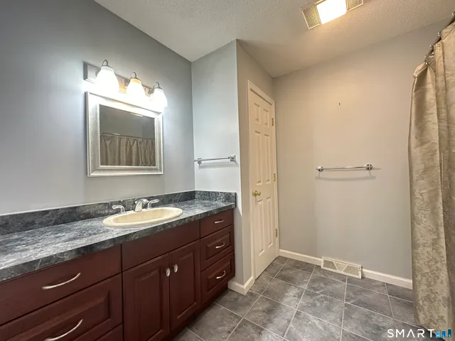 a bathroom with a granite countertop sink and a mirror