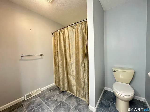 a bathroom with a toilet and a shower