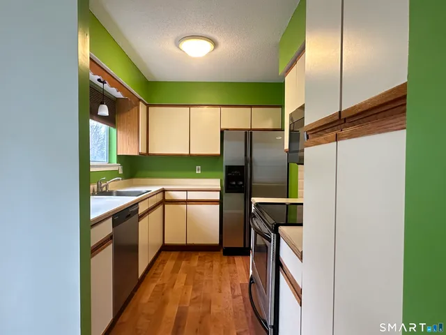 a kitchen with a sink a refrigerator and cabinets