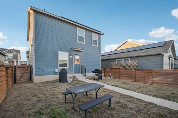 a backyard of a house with barbeque oven and outdoor seating