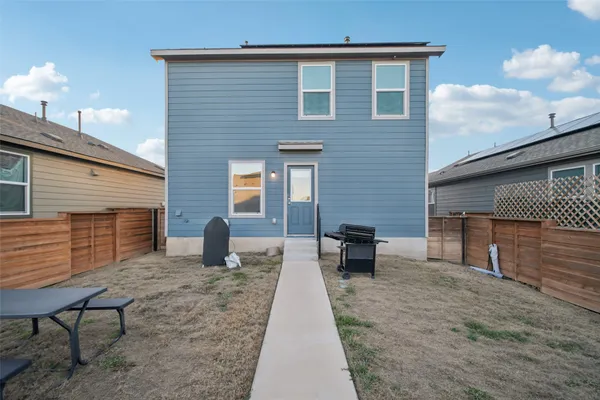 a backyard of a house with barbeque oven and bench