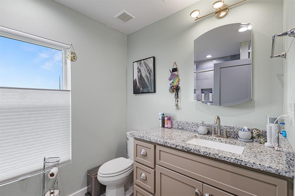 124 County Road 4511 Decatur, TX 76234 - Photo 17 of 39 a bathroom with a granite countertop toilet sink and mirror
