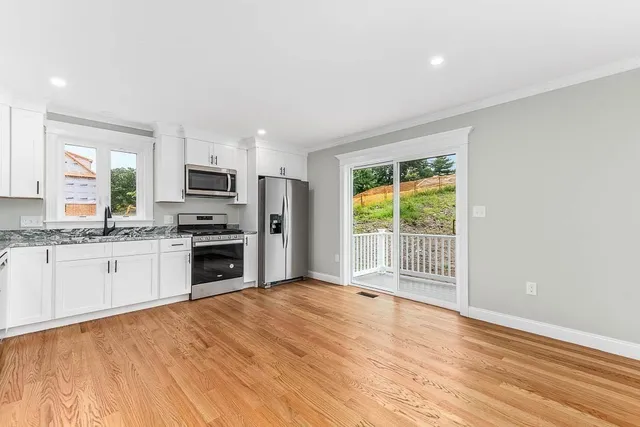 a kitchen with granite countertop a stove a sink and a refrigerator