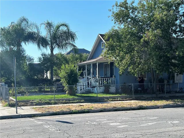 a front view of a house with a yard and palm trees