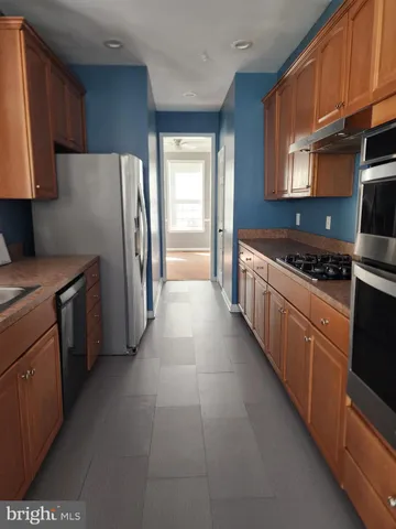 a kitchen with stainless steel appliances a stove a refrigerator and a sink