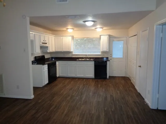 a kitchen with granite countertop a stove and cabinets