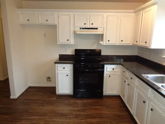 a kitchen with stainless steel appliances granite countertop a refrigerator and a stove