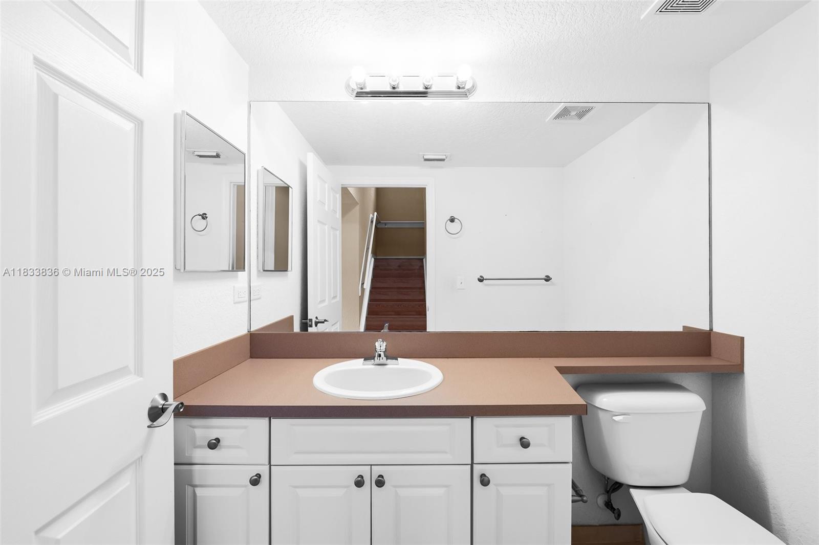 6722 West Sample Road, Unit 6722 Coral Springs, FL 33067 - Photo 12 of 23 a bathroom with a sink toilet and mirror