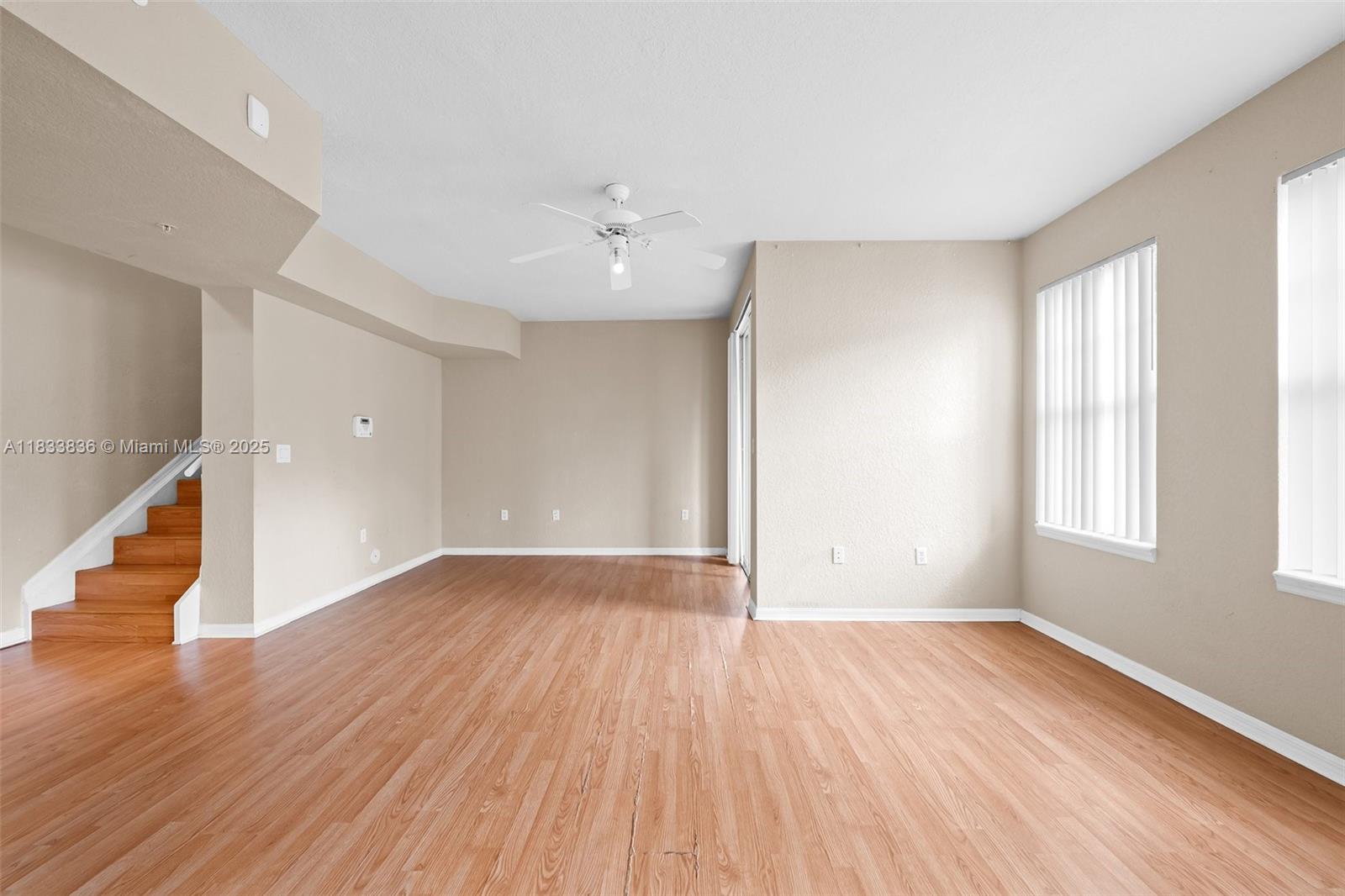6722 West Sample Road, Unit 6722 Coral Springs, FL 33067 - Photo 6 of 23 an empty room with wooden floor and windows