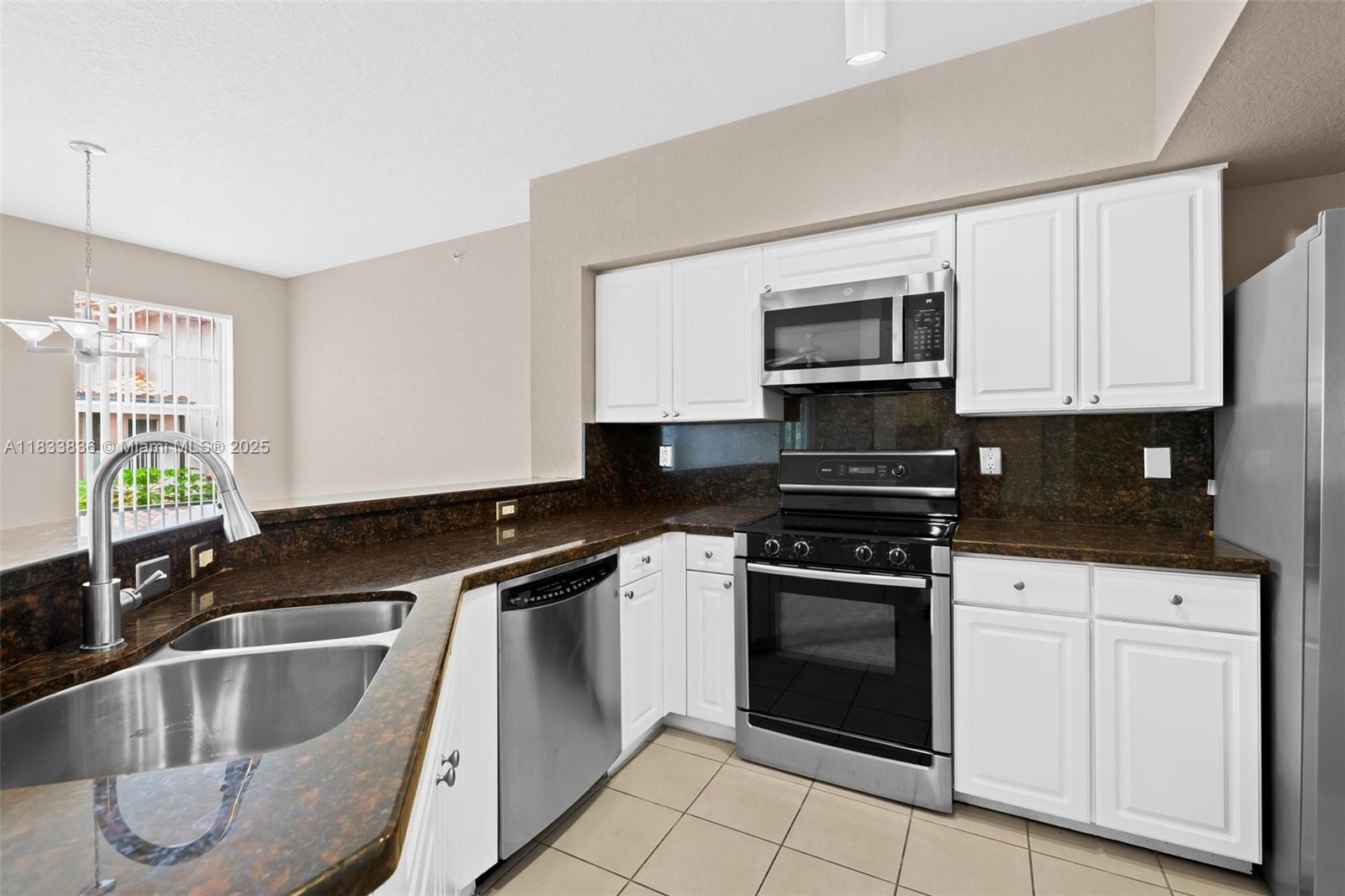 6722 West Sample Road, Unit 6722 Coral Springs, FL 33067 - Photo 8 of 23 a kitchen with granite countertop a sink stainless steel appliances and cabinets