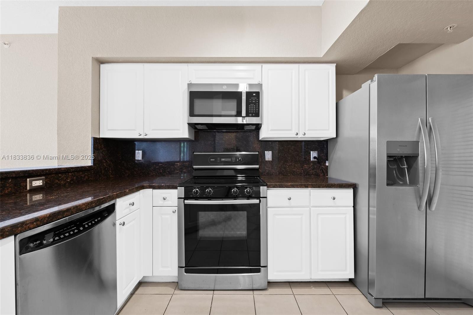 6722 West Sample Road, Unit 6722 Coral Springs, FL 33067 - Photo 9 of 23 a kitchen with white cabinets and stainless steel appliances