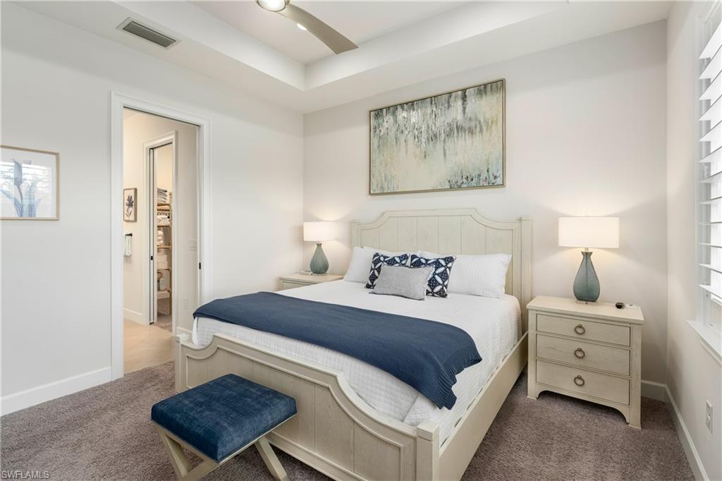 6847 Saona Court Naples, FL 34113 - Photo 11 of 47 a bedroom with a bed a lamp and a window