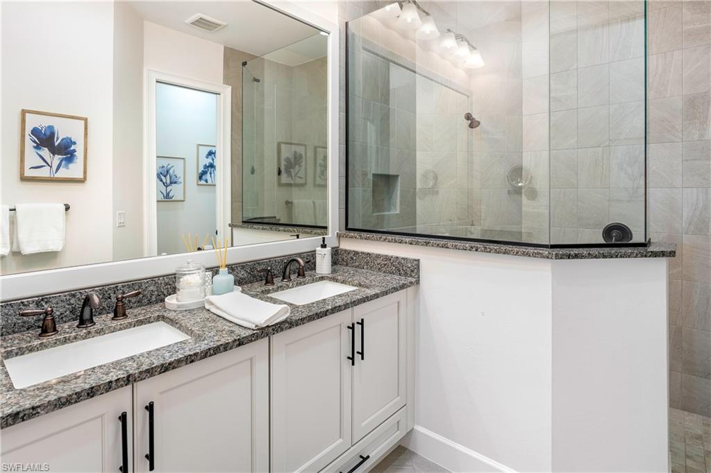 6847 Saona Court Naples, FL 34113 - Photo 13 of 47 a bathroom with a granite countertop sink and a mirror