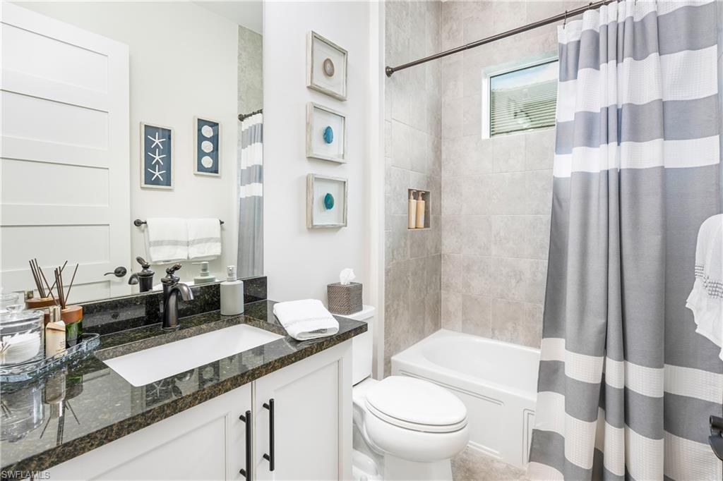 6847 Saona Court Naples, FL 34113 - Photo 15 of 47 a bathroom with a granite countertop sink mirror vanity and toilet