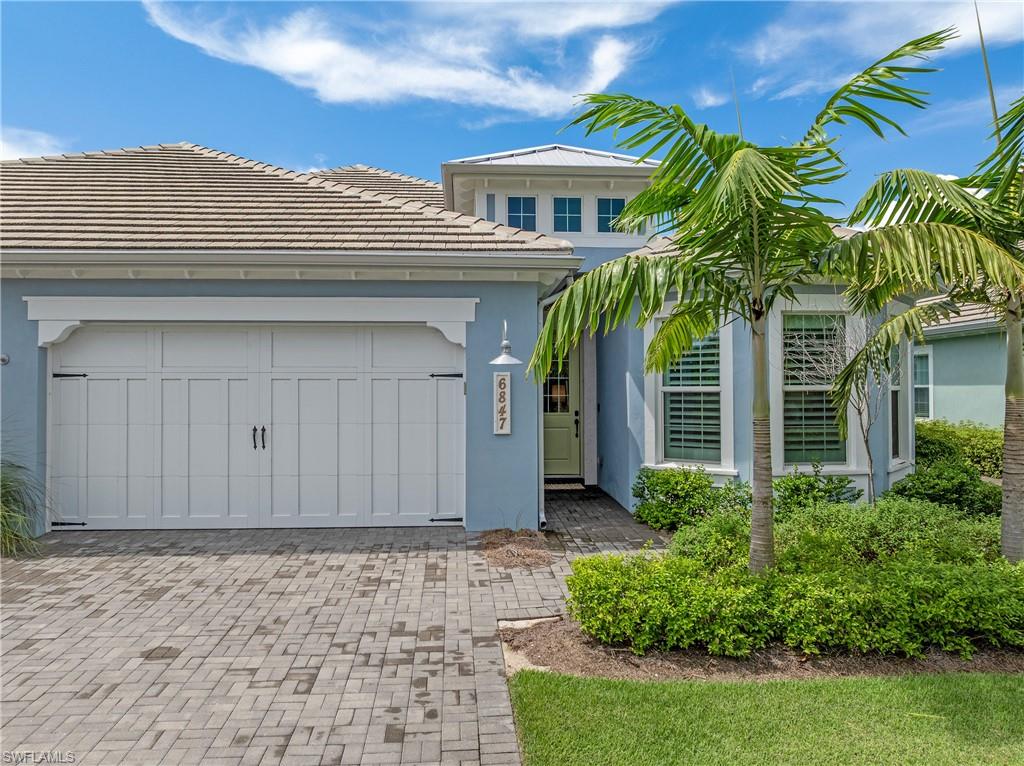 6847 Saona Court Naples, FL 34113 - Photo 20 of 47 a view of a house with a yard and plants