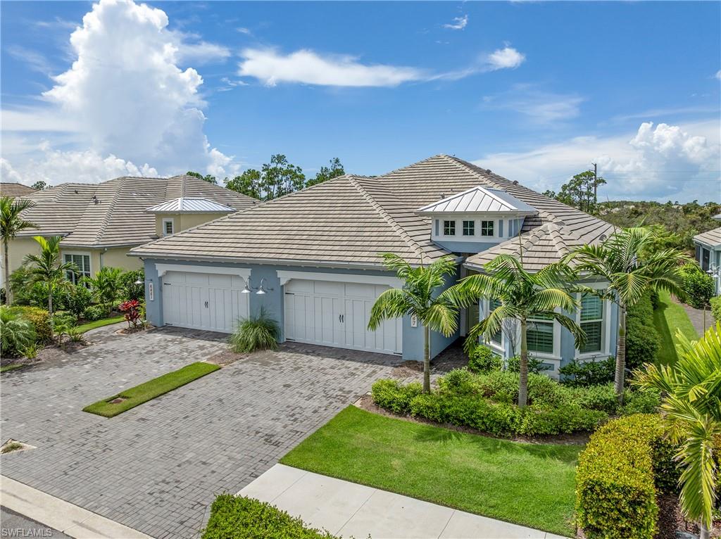 6847 Saona Court Naples, FL 34113 - Photo 24 of 47 a front view of a house with a garden and plants