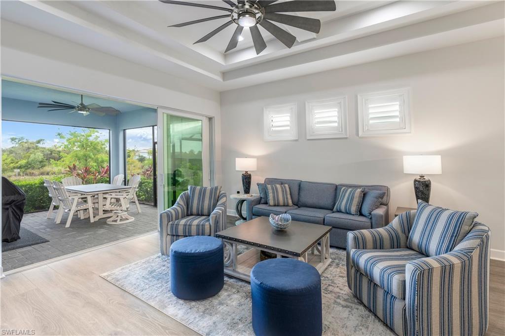 6847 Saona Court Naples, FL 34113 - Photo 4 of 47 a living room with furniture and a large window