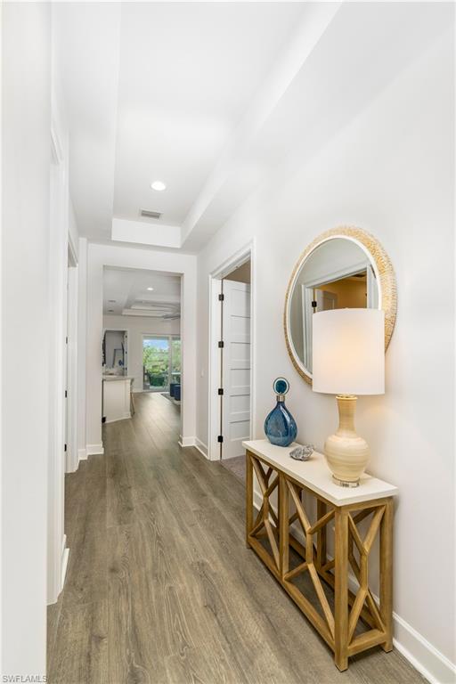 6847 Saona Court Naples, FL 34113 - Photo 6 of 47 a living room with furniture a mirror and a wooden floor