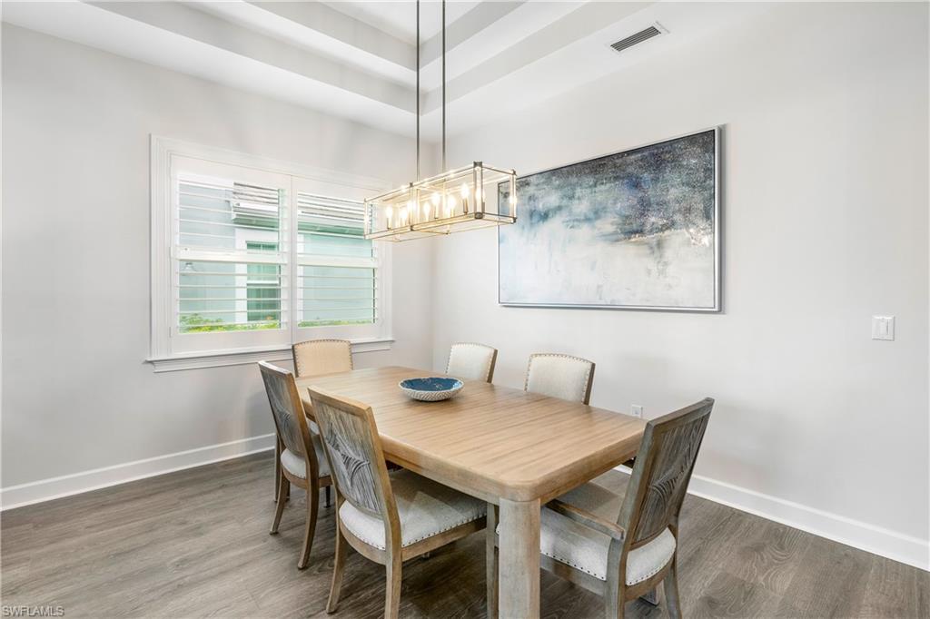 6847 Saona Court Naples, FL 34113 - Photo 10 of 47 a view of a dining room with furniture large windows and wooden floor