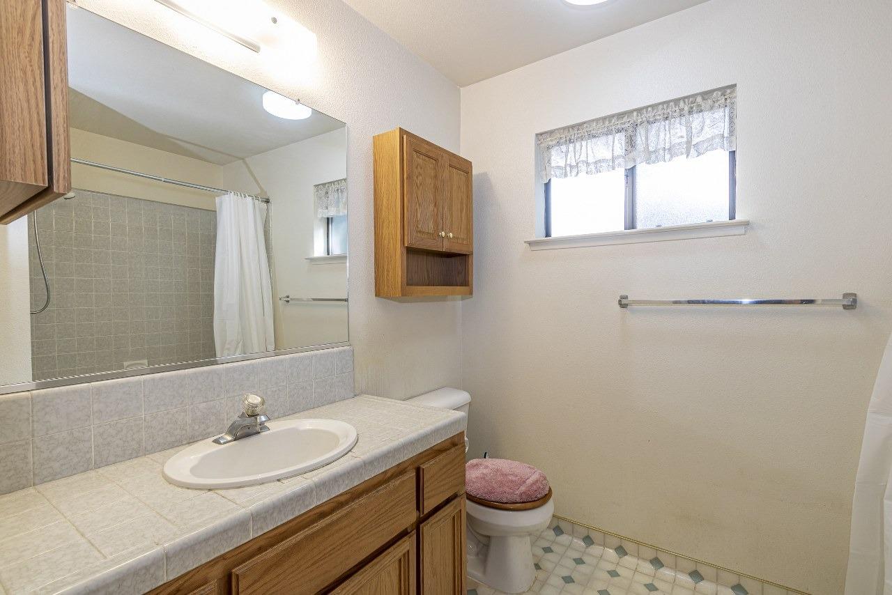 59634 Cascadel Drive North Fork, CA 93643 - Photo 20 of 52 a bathroom with a granite countertop sink toilet and mirror