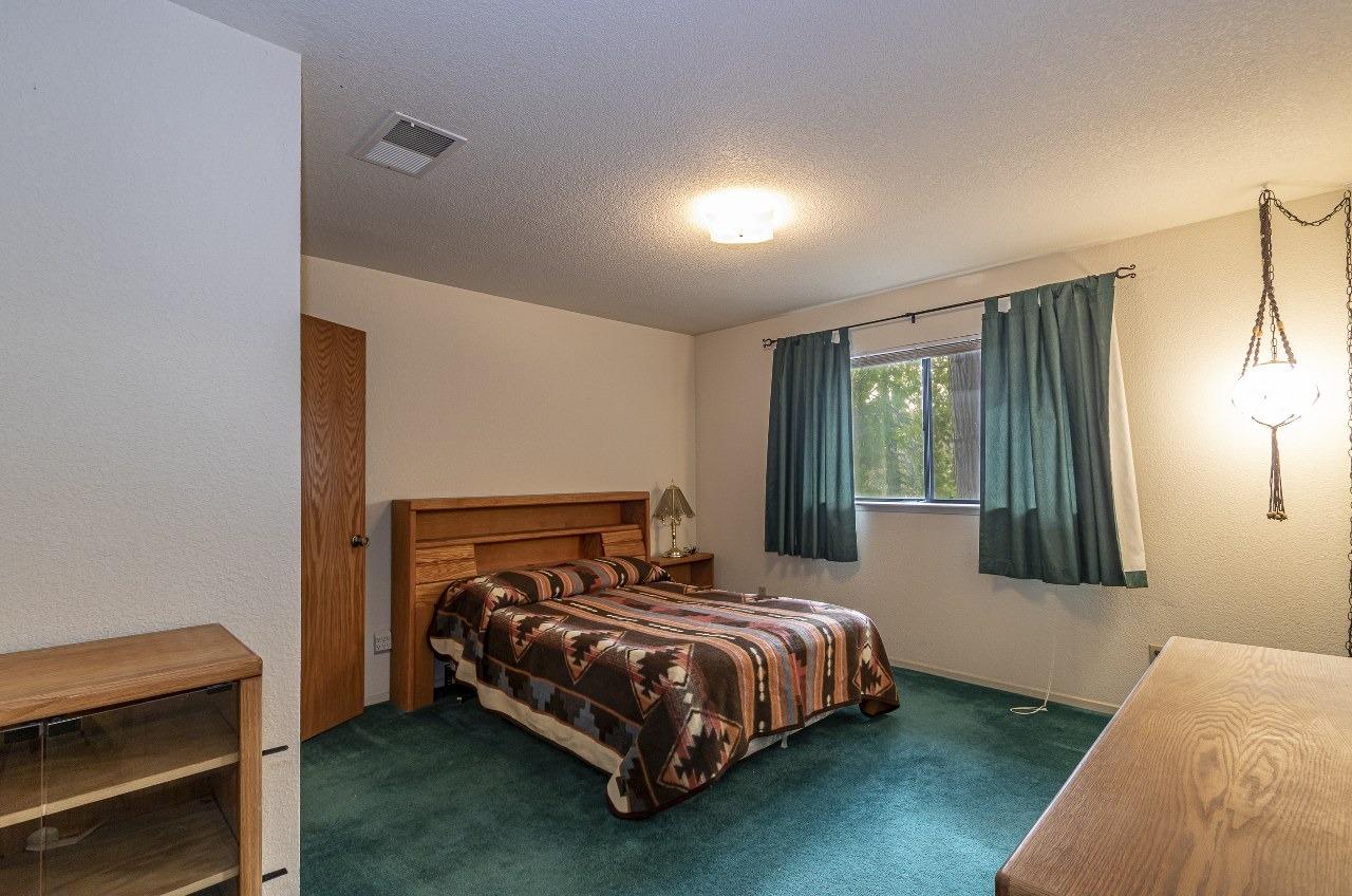 59634 Cascadel Drive North Fork, CA 93643 - Photo 24 of 52 a bedroom with a bed lamp and a window