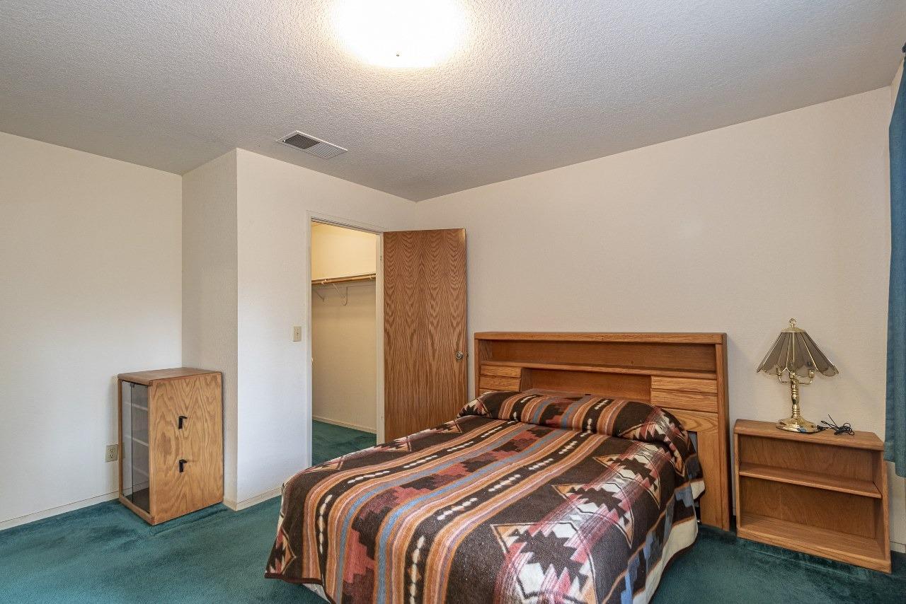 59634 Cascadel Drive North Fork, CA 93643 - Photo 25 of 52 a bedroom with a bed and a lamp