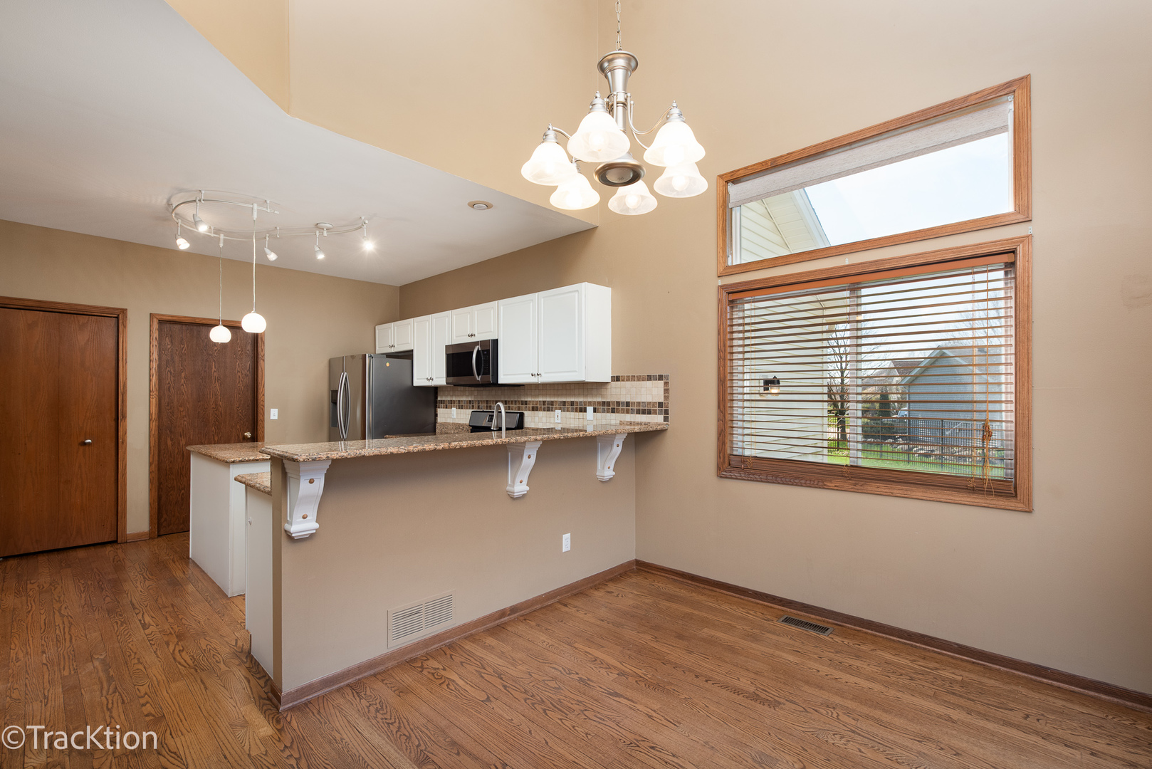 323 Mallard Lane Sugar Grove, IL 60554 - Photo 11 of 32 a kitchen with stainless steel appliances granite countertop a refrigerator a sink dishwasher a stove and a dining table with wooden floor